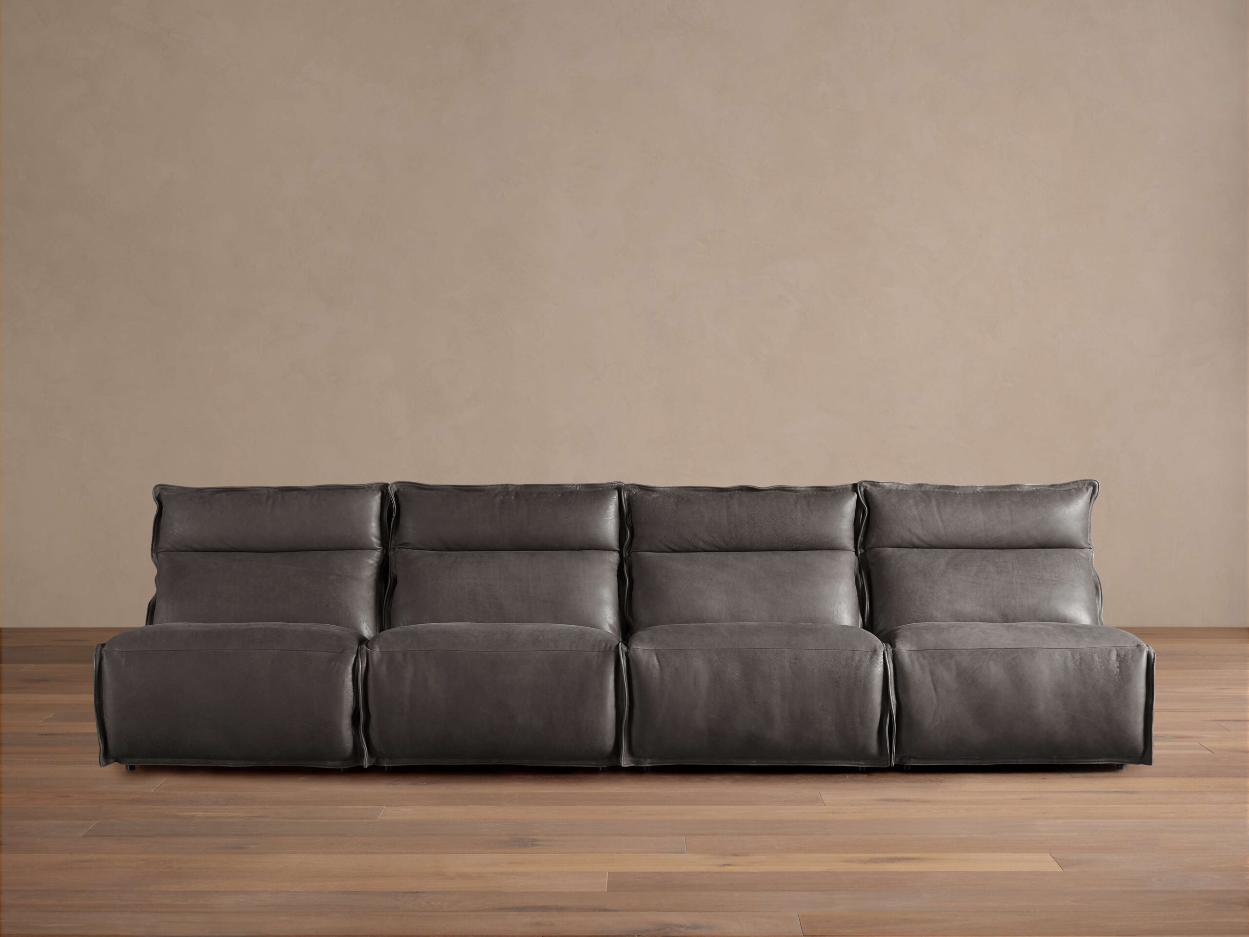 Rowland Leather Four-Piece Armless Motion Modular Sofa in dark brown leather, four recliners aligned, set on wooden floor.