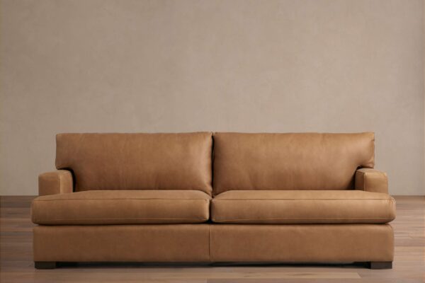 Tan Dune Leather Sofa with a sleek, modern design featuring two seat cushions and two back cushions. Set against a neutral background.